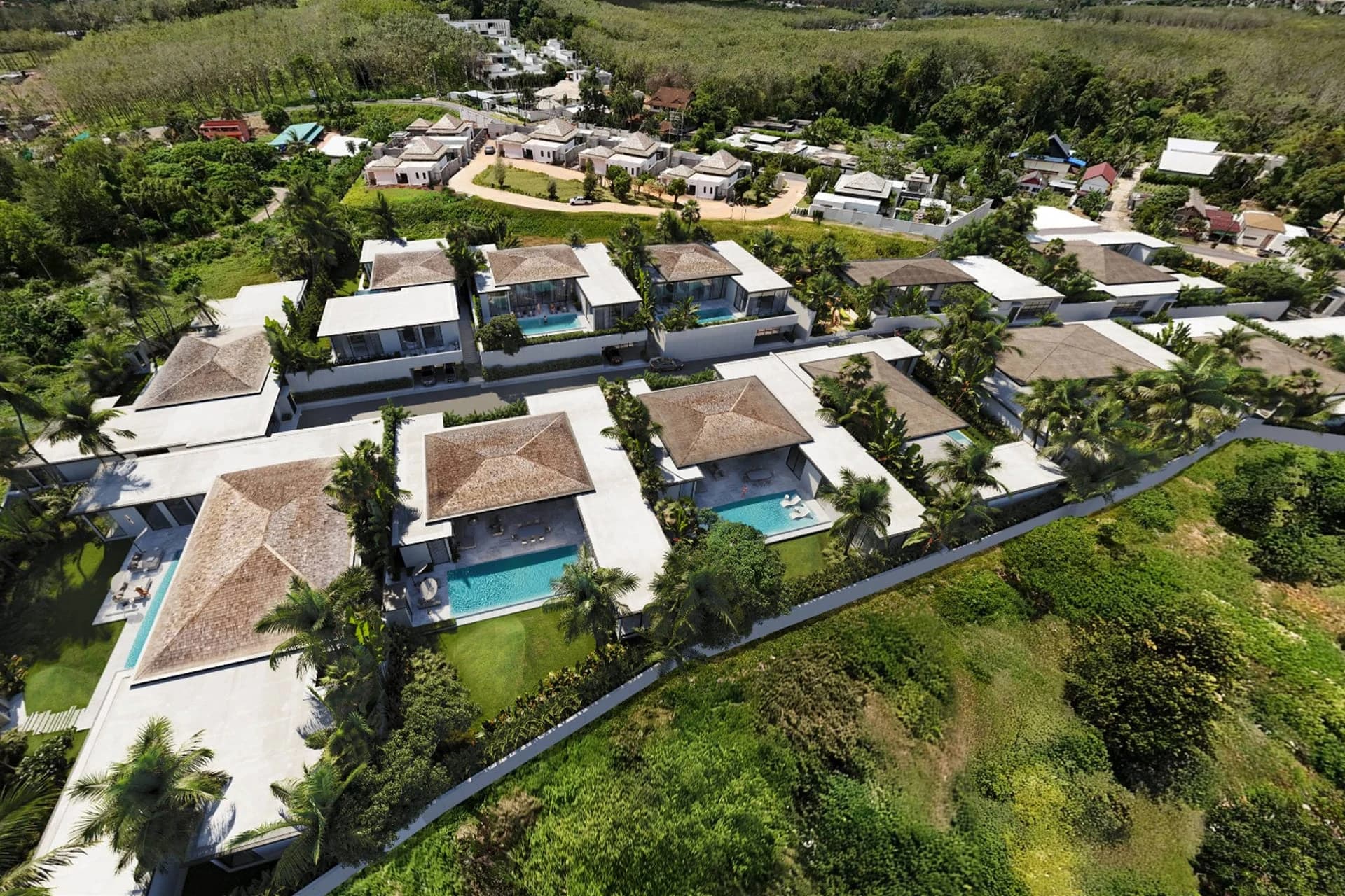 The estate from the air: single-level villas with pools along the lane, the hills behind