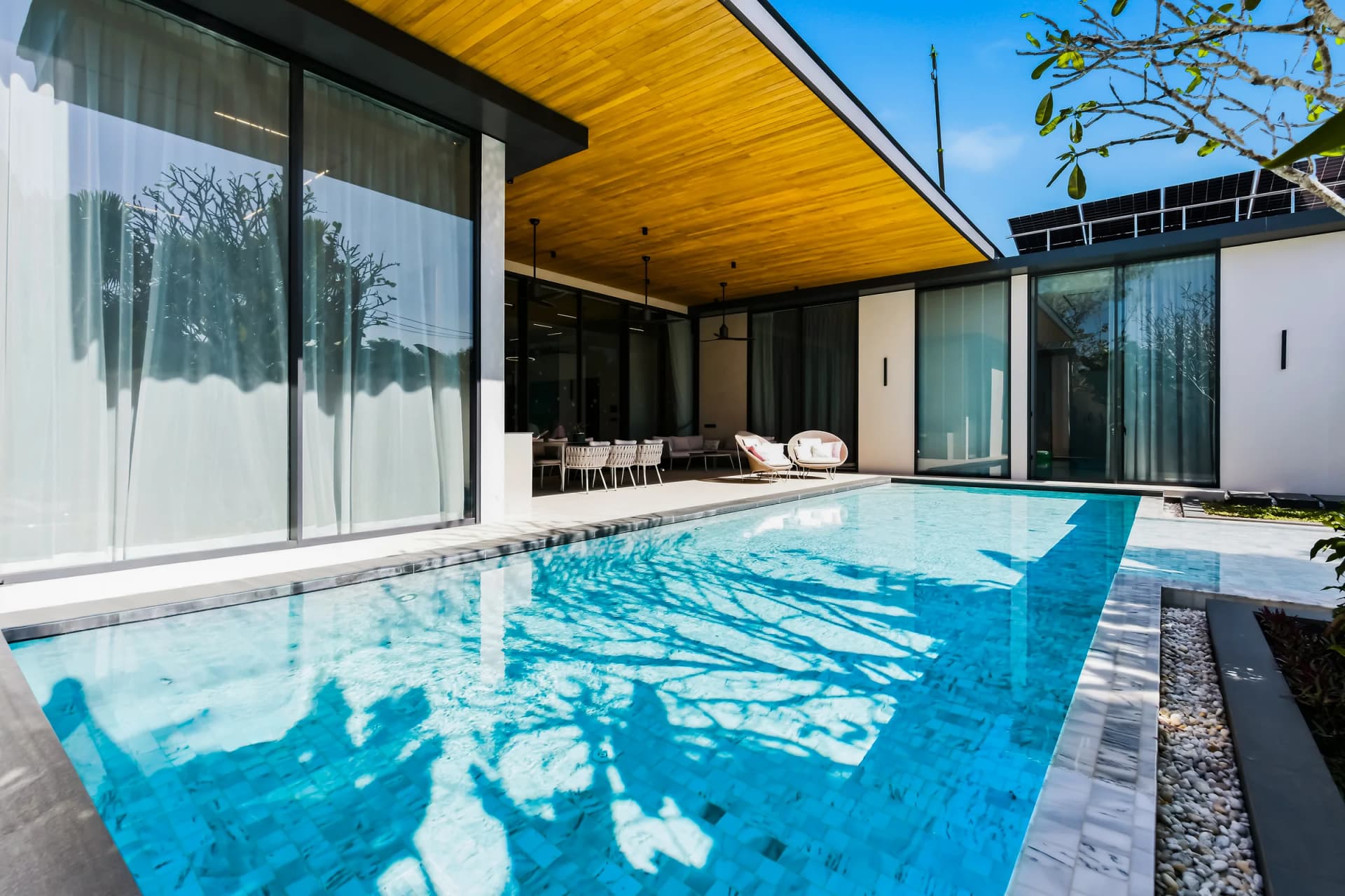 Villa 1, completed: the pool in front of the covered terrace under a cedar ceiling